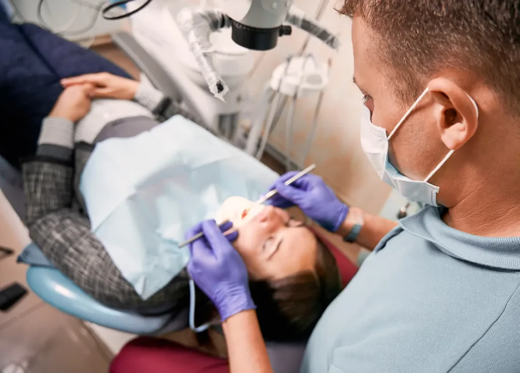 As a family dentist, Legacy Smiles is a quality provider. A dentist examines a patient's teeth as part of preventative dental care.