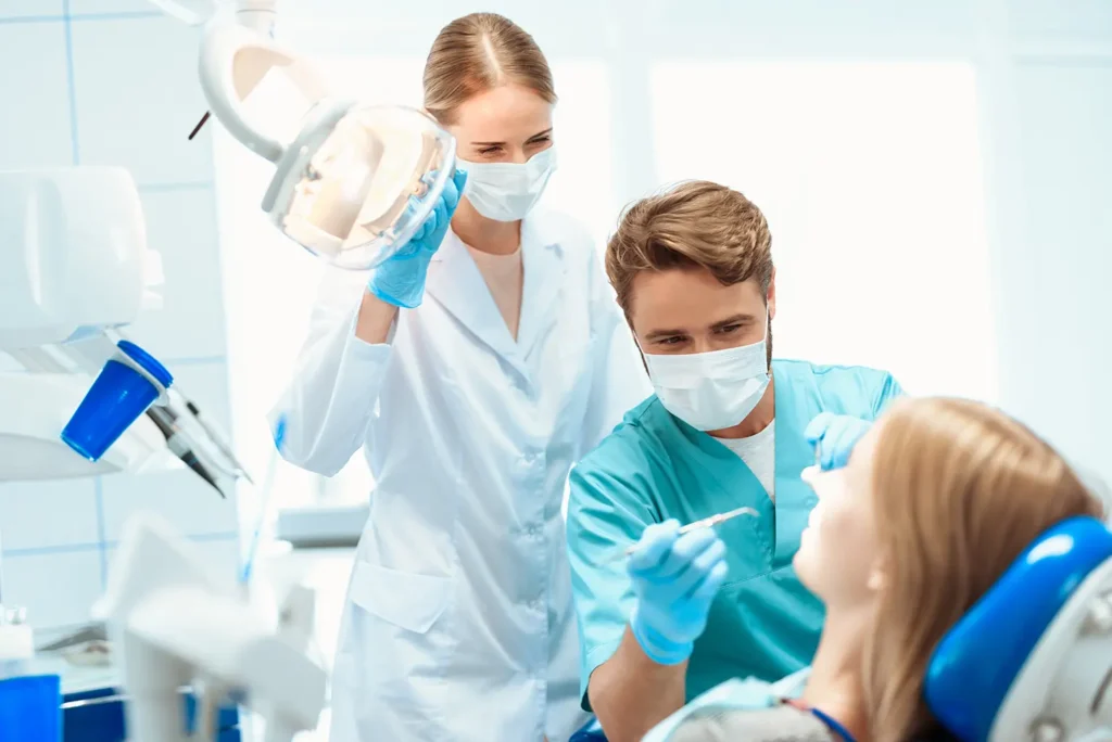 Dentist and hygienist treating a patient in a dental office, emphasizing the importance of wisdom teeth care for maintaining heart health.