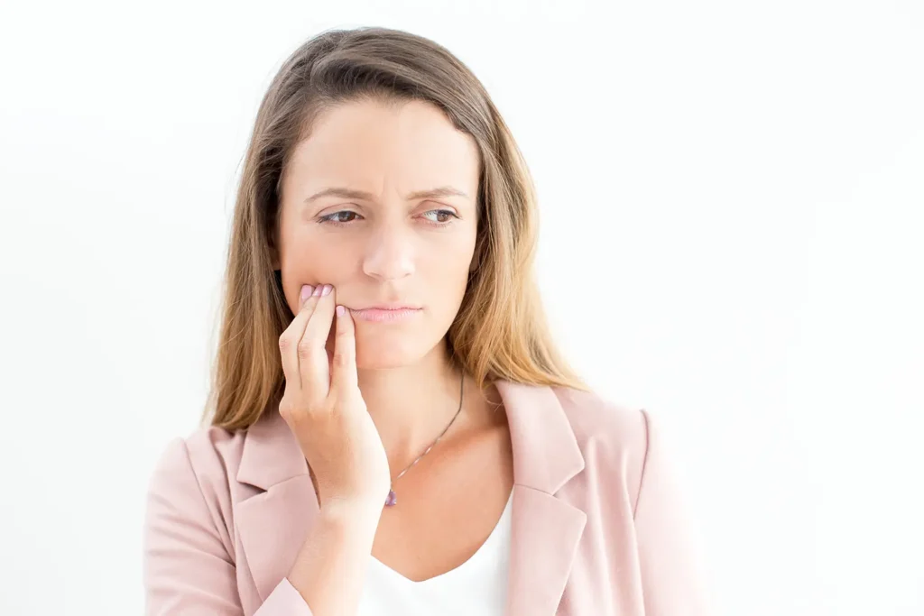 Displeased businesswoman suffering from toothache, indicating possible gum disease, concerned about oral health.